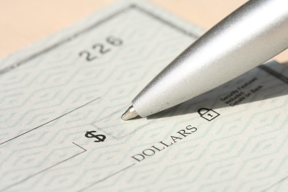 Pen poised over a check, ready to write.