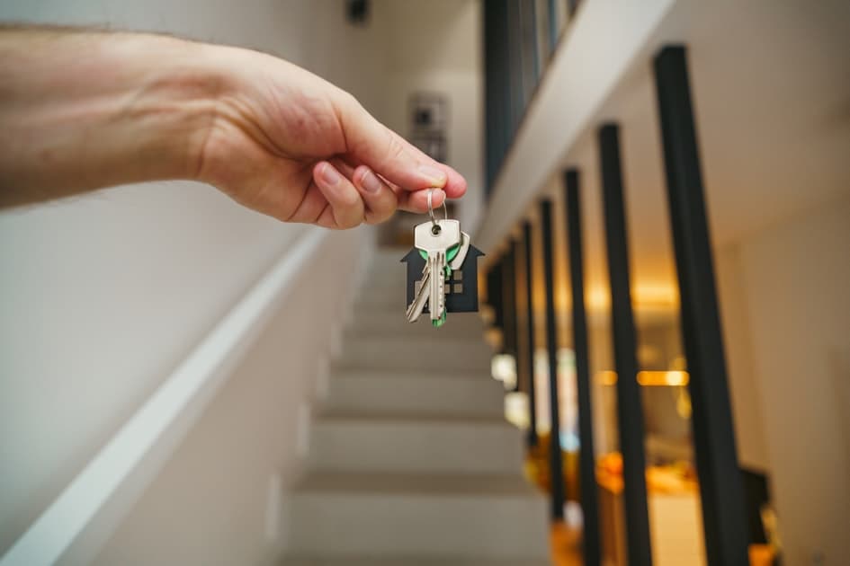 New homeowner holding house keys in front of their first Florida home