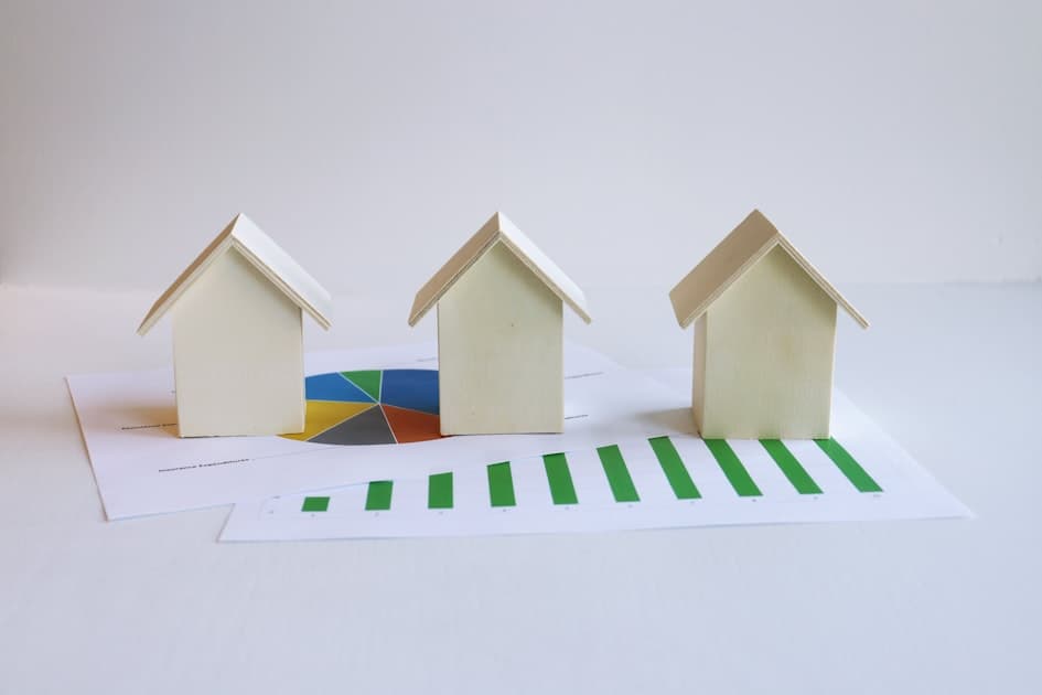 Model homes on mortgage documents illustrating PMI costs for first-time buyers